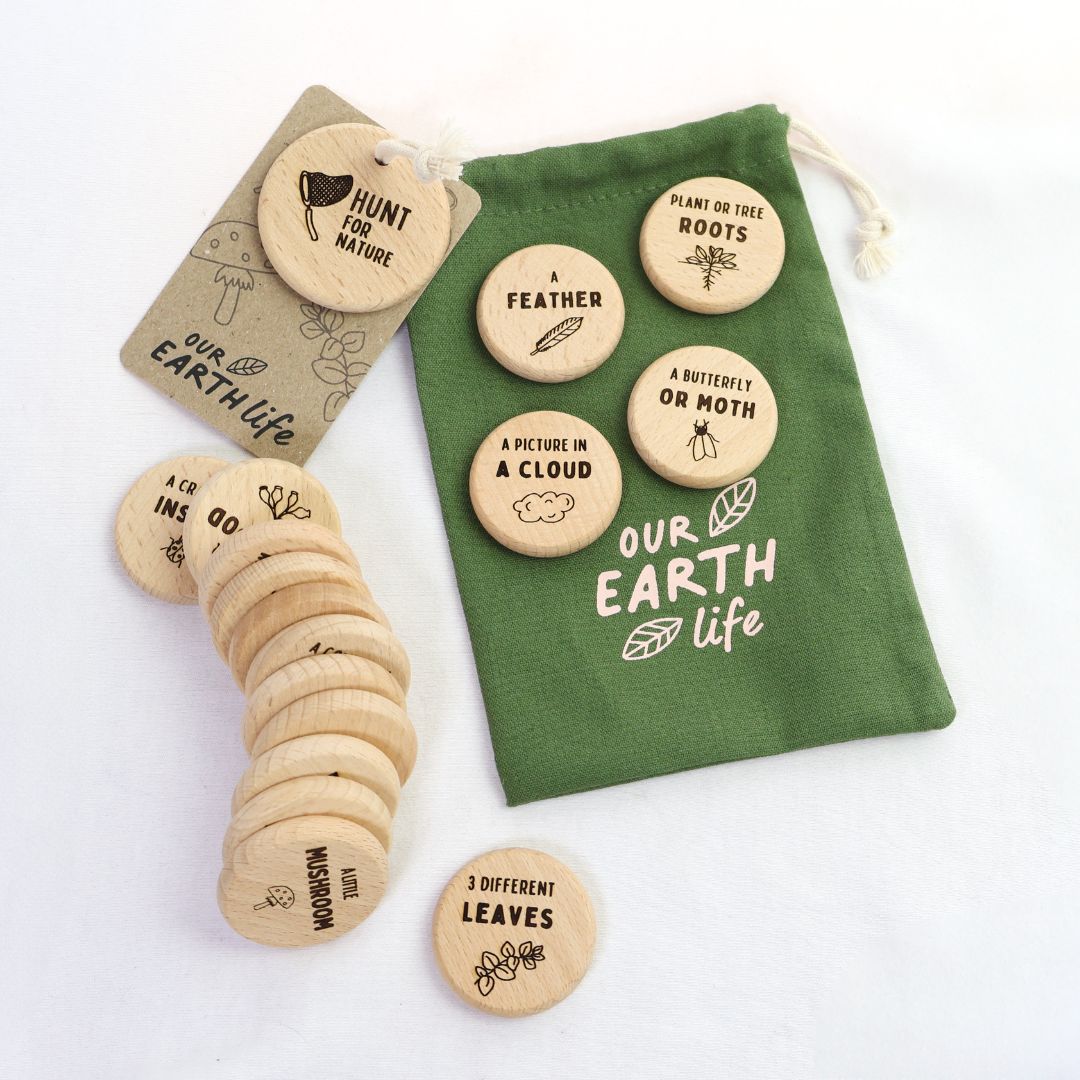 Wooden nature-themed discovery discs with a green drawstring bag on a white background