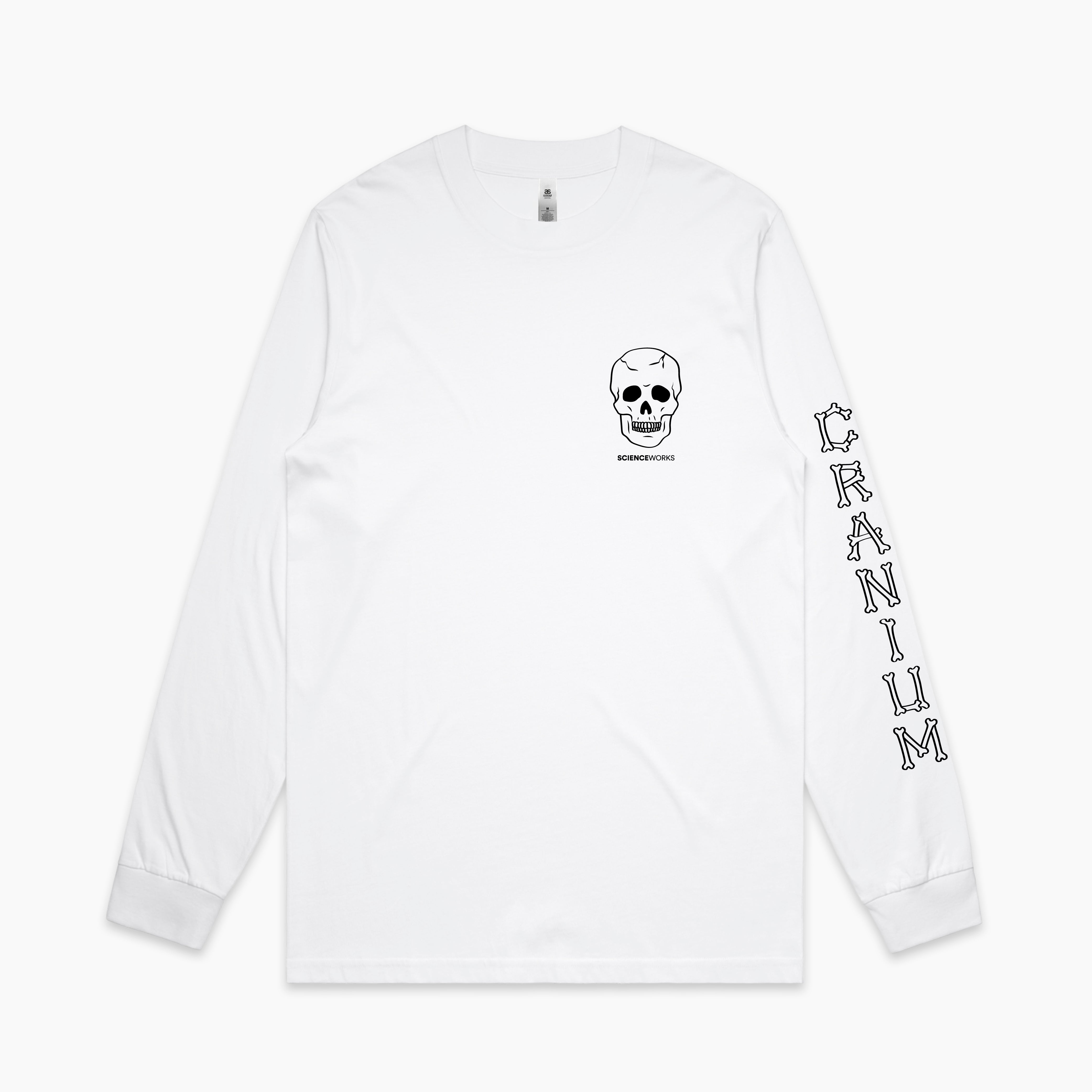 The front view of a white adult's long sleeve tee. On the left chest is a small human skull with Scienceworks written in small font underneath. The left sleeve has CRANIUM written on it in a font made of bones.